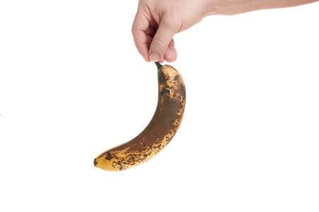 Hand holds a ripe banana on a white background, template for designersの写真素材