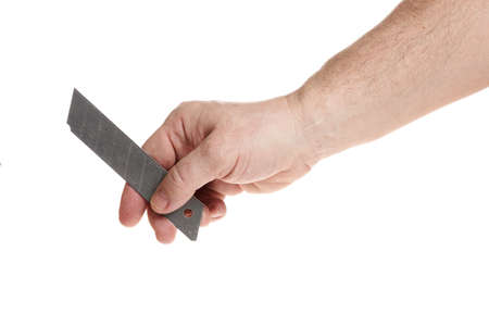 Hand holds a blade for a construction knife on a white backgroundの写真素材