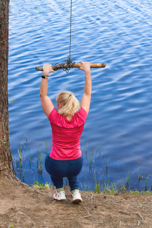 Girl in sportswear prepares for bungee jumping over waterの写真素材