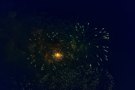 Blurred multicolored fireworks lights against the dark night sky