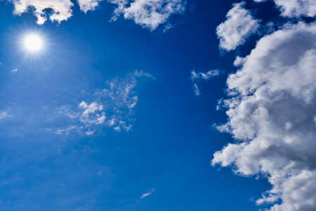 Silhouette of a helicopter against a blue sky with cloudsの写真素材