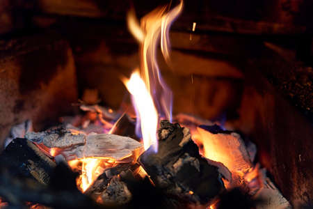 Burning black coals and fire bred in the fireplace. Close upの写真素材