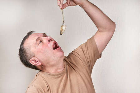 A man pulls out a smelt fish gnawed to the bone with his handの写真素材
