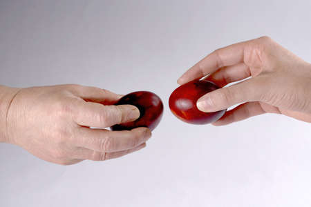 two hands hold eggs and try to break each other eggの写真素材