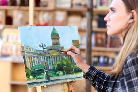An unknown artist paints the Kazan Cathedral on a street in St. Petersburgのeditorial素材