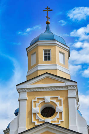 Fragment of the bell tower of a Christian church with a blue roof. Church bell tower against the skyの写真素材