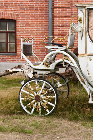 Old white carriage on the background of a red brick building. White vintage carriageの写真素材
