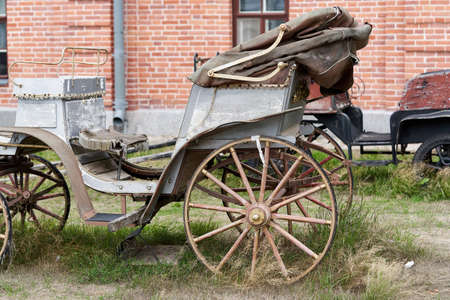 Old white carriage on the background of a red brick building. White vintage carriageの写真素材