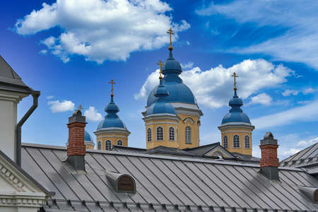 Fragment of the bell tower of a Christian church with a blue roof. Church bell tower against the skyの写真素材