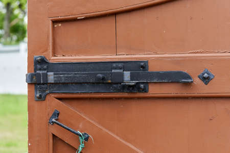 Fragment of an old fortress door with forged metal bolts and locks. Antique locks on wooden gatesの写真素材