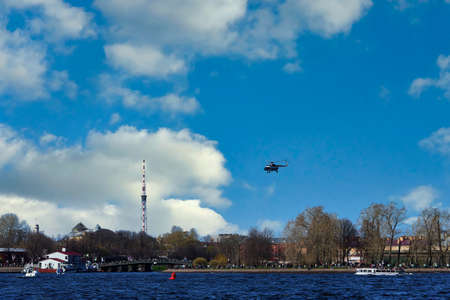 The helicopter takes off against the background of clouds and blue skyの写真素材