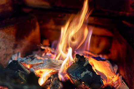 Burning black coals and fire bred in the fireplaceの写真素材