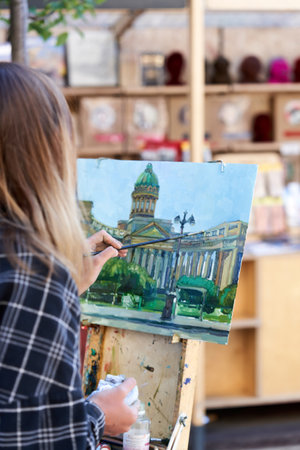 An unknown artist paints the Kazan Cathedral on a street in St. Petersburgのeditorial素材