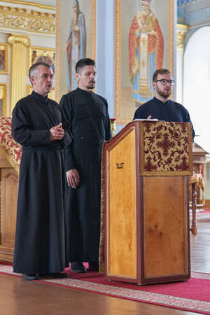 Priests in black robes conduct a service in a Christian churchのeditorial素材