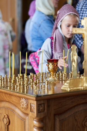 A young parishioner lights a candle at the altar in the church