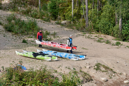 Men carry kayaks to the water, preparing for the competitionのeditorial素材