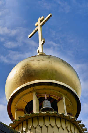 Fragment of the bell tower of a Christian church with a blue roof. Church bell tower against the skyの写真素材