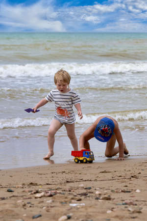 Two little boys are playing on the seashoreの写真素材