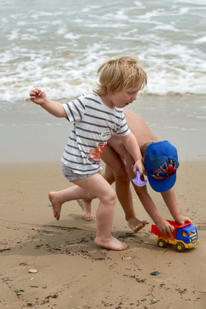 Two little boys are playing on the seashoreの写真素材