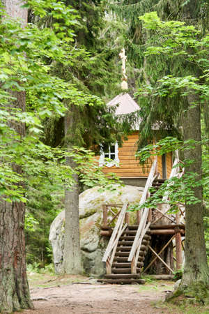 Small wooden house on a large stone in the forestの写真素材