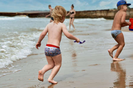 Two little boys are playing on the seashoreの写真素材