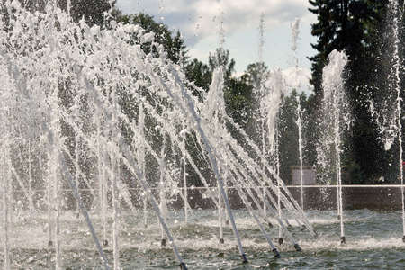 Fragment of a city fountain with water jets and splashesの写真素材