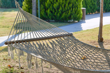 Rope hammock hanging between the trees to relax on a hot summer day. Empty hammock close upの写真素材
