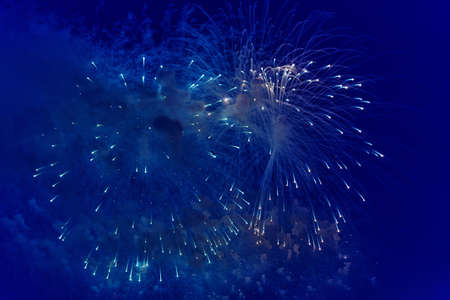 Blurred multicolored fireworks lights against the dark night skyの写真素材