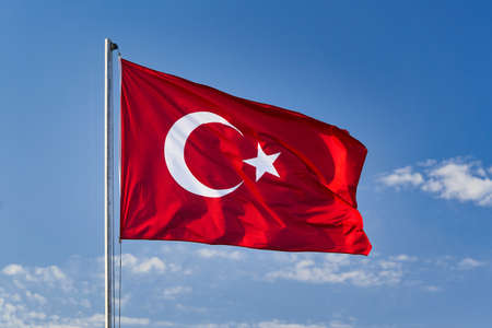 Turkish flag waving in the wind against the background of the skyの写真素材