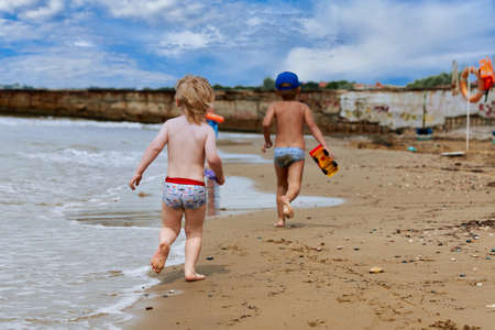 Two little boys are playing on the seashoreの写真素材