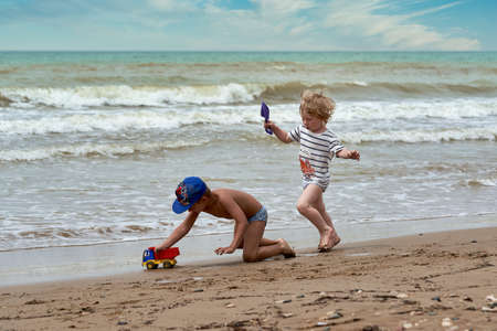 Two little boys are playing on the seashoreの写真素材