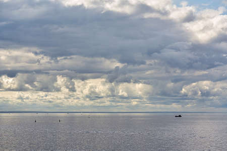 Marine skyline with dark storm clouds and smooth waterの写真素材