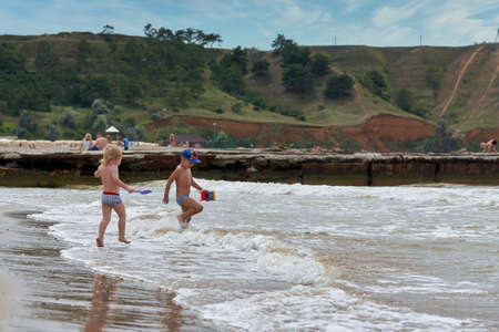 Two little boys are playing on the seashore. Children playing on the beachの写真素材