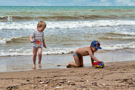 Two little boys are playing on the seashoreの写真素材