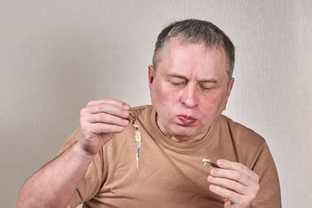 Man eating fried smelt fish holding fish with hands in front of faceの写真素材