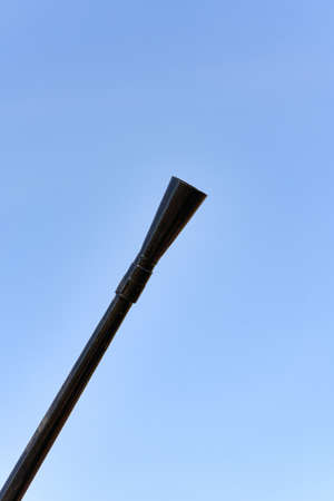 Barrel of a machine gun in a diagonal frame against a blue skyの写真素材