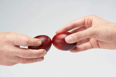 two hands hold eggs and try to break each other eggの写真素材