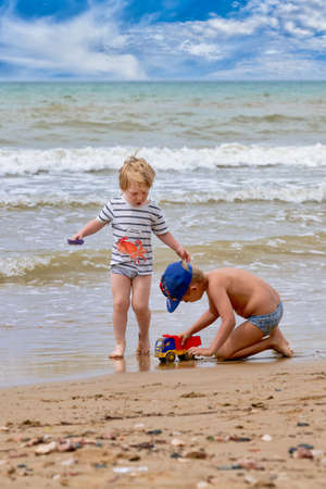 Two little boys are playing on the seashoreの写真素材