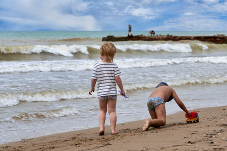 Two little boys are playing on the seashoreの写真素材