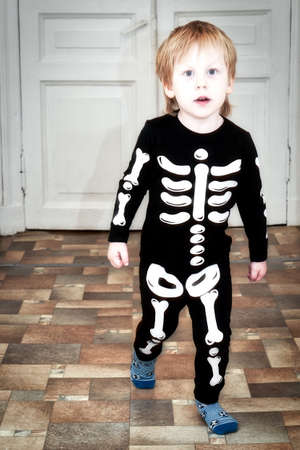 A child in a skeleton costume is dancing in the hallway of the houseの写真素材
