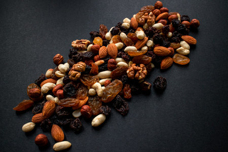 Nuts and dried fruits on a black background. Useful food for weight loss and diet. Background....