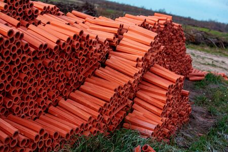 Ceramic drainage pipes of red color for the external sewerage. Traditional material, inside the shape of a hollow cylinder. Absolute environmental friendliness and water drainage from the site.の写真素材
