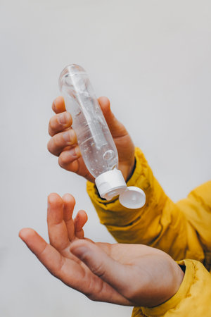 Bottle with gel in childrens hands. Protection against bacteria. Antiseptic treatment. The...