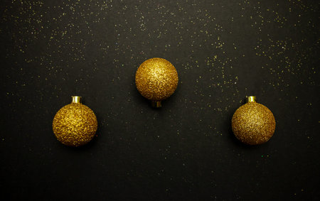 Golden Christmas Balls over black background with copy space for text or other design. High quality...