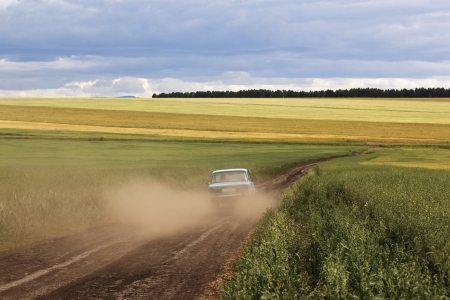 an old car on ground road in the fieldsの写真素材