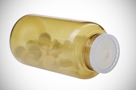 Closed brown jar with pills  isolated on white backgroundの写真素材