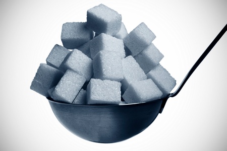 ladle full with sugar cubes isolated on whiteの写真素材