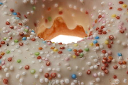 Iced Doughnut covered in sprinkles isolated on white background の写真素材