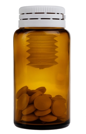 a brown bottle with pills over whiteの写真素材