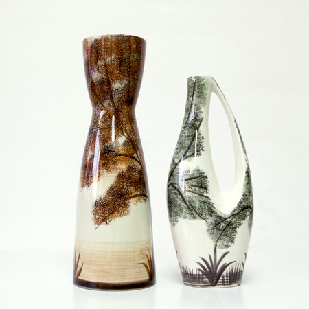 American ceramic pair in white brown and green tones: two vases of 1950-th years. Unusual forms, glazed surfaces, floral drawing. Symbolizes couple: He and She; Brother and sister, bride and groom etc. Isolated on white.の写真素材